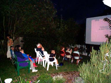 (picture of people watching backyard outdoor movie)
